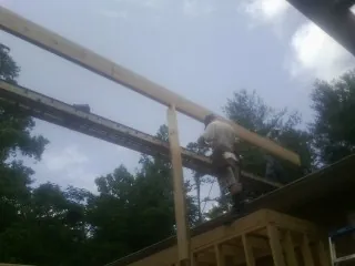 Carpenter setting a ridge beam over a new addition frame — Ice Dam Removal by Roofing Brothers in Isle Of Palms