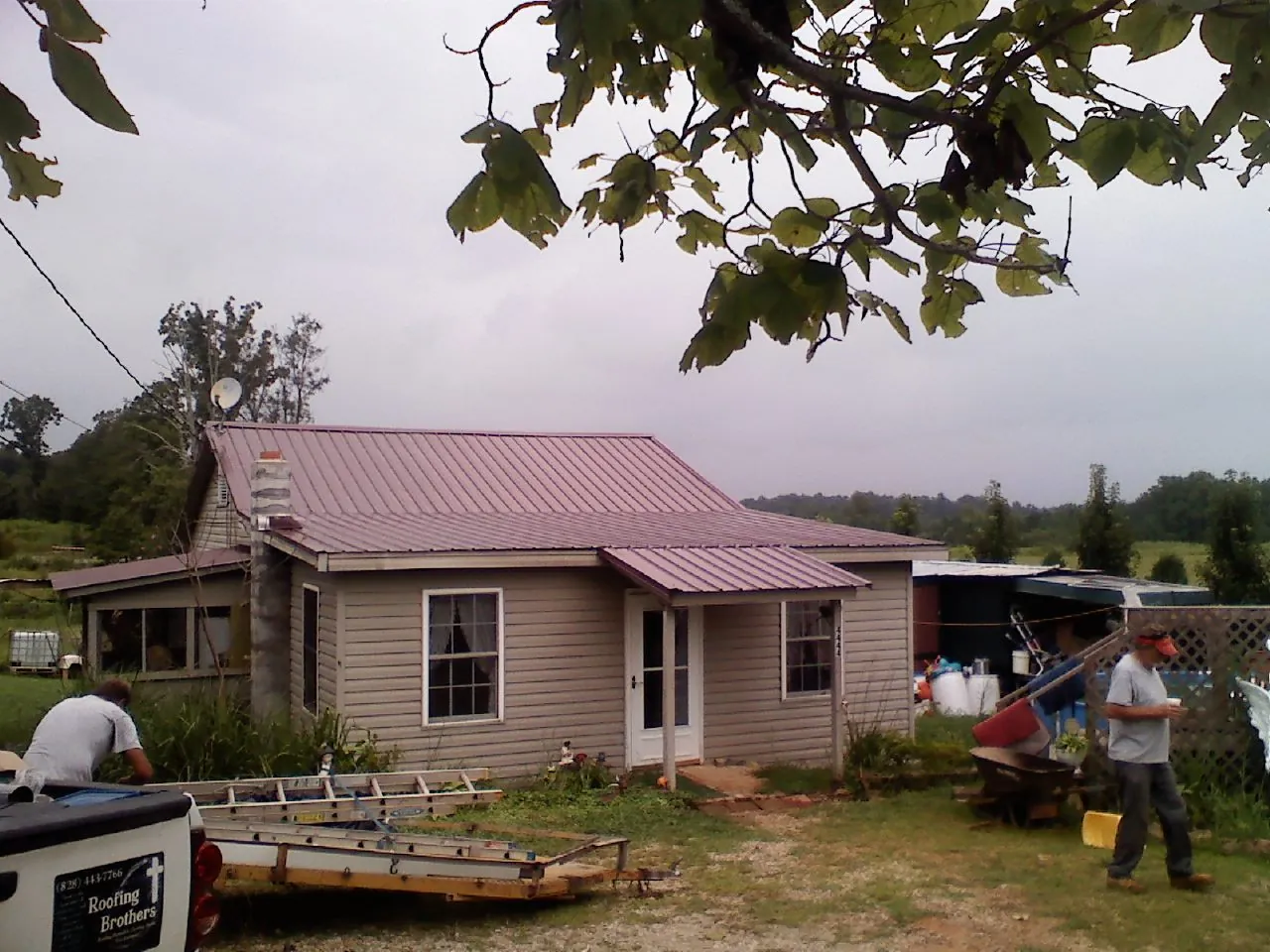 Crew finishing a mauve metal roof on a small farmhouse in Isle Of Palms