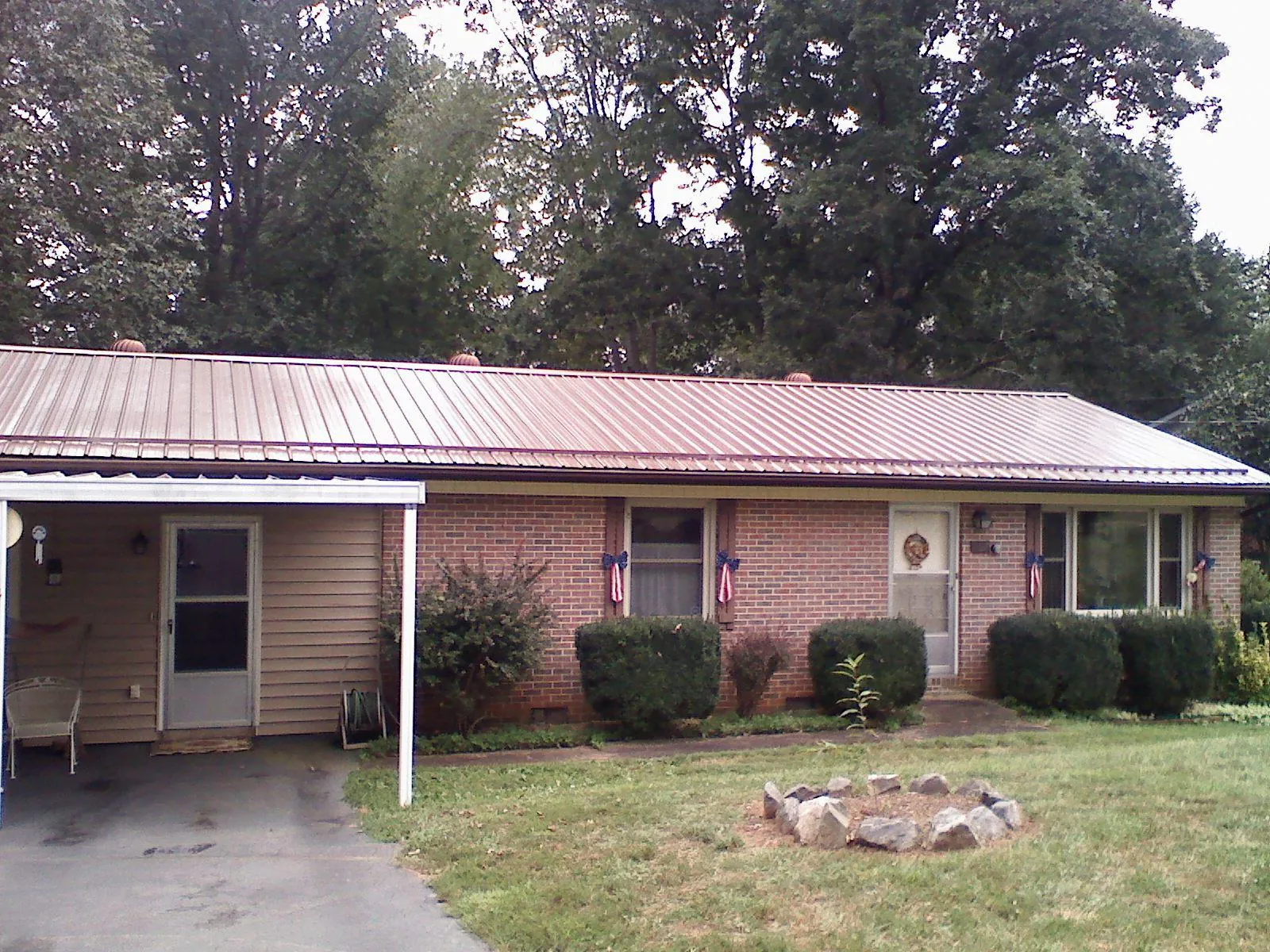 Bronze metal roof and carport on a brick ranch home — Roof Repair work by our crew in Isle Of Palms